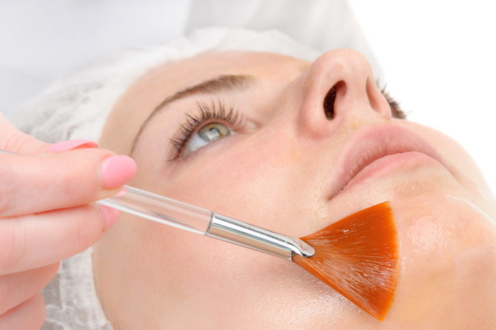 applying peeling mask to woman's face