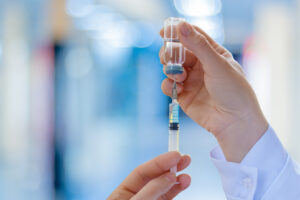 The doctor fills a syringe with injectable treatment